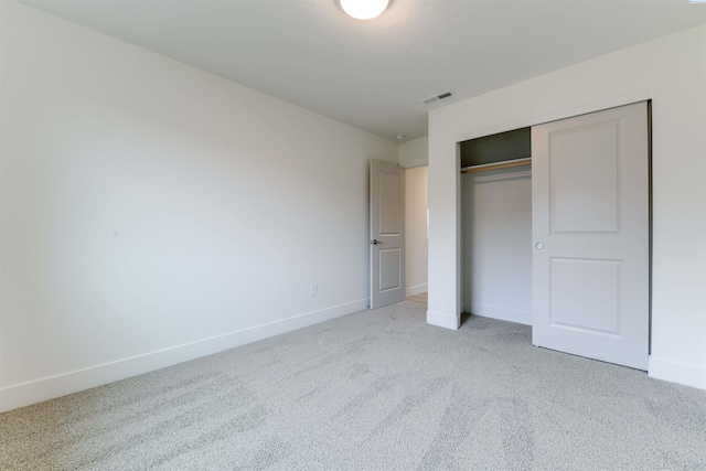 unfurnished bedroom with carpet flooring, baseboards, and a closet