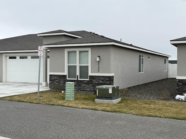 2730 Westhaven Ct, West Richland, WA 99353 - view of front of property featuring roof with shingles, stucco siding, a garage, stone siding, and driveway