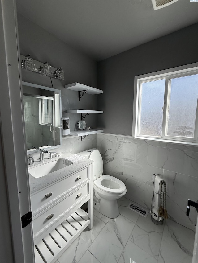 227 E 5th Ave, Kennewick, WA 99336 - full bath with visible vents, vanity, marble finish floor, toilet, and tile walls