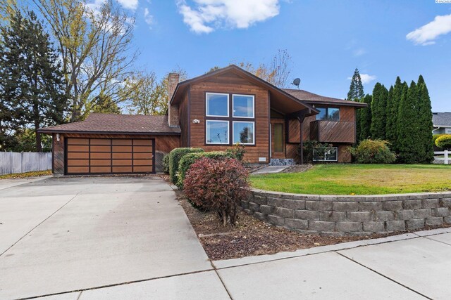 view of front of home with a garage and a front lawn