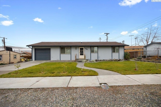 ranch-style home with a garage and a front lawn