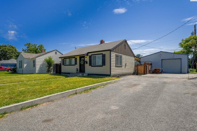 742 E 4th Ave, Kennewick, WA 99336 - view of front of property featuring an outdoor structure, board and batten siding, driveway, a chimney, and a garage