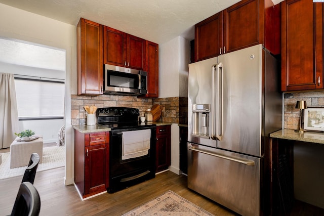 742 E 4th Ave, Kennewick, WA 99336 - kitchen with stainless steel appliances, dark brown cabinets, dark wood-style flooring, and decorative backsplash