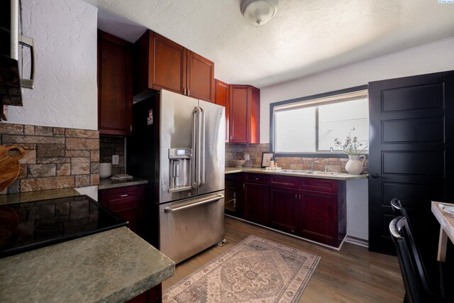 742 E 4th Ave, Kennewick, WA 99336 - kitchen featuring stainless steel fridge with ice dispenser, a sink, reddish brown cabinets, and backsplash