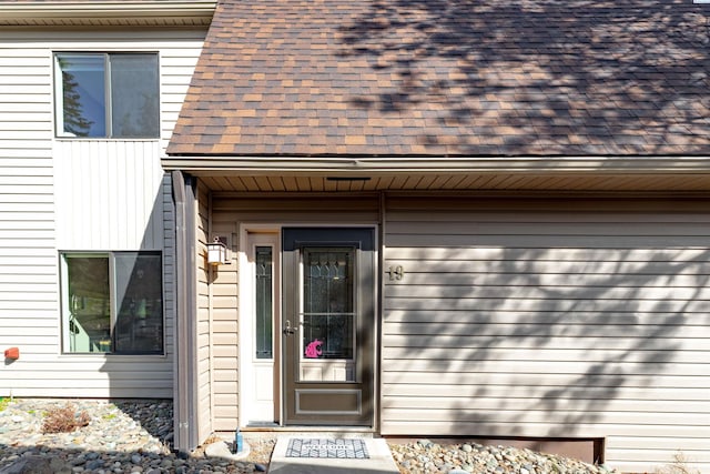 property entrance featuring a shingled roof