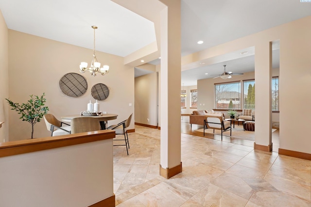 dining area with ceiling fan with notable chandelier