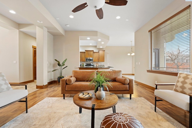 living room featuring light hardwood / wood-style floors and ceiling fan