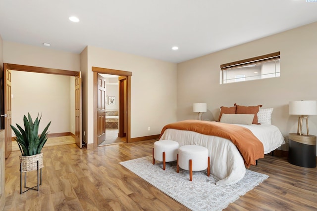 bedroom featuring hardwood / wood-style floors and ensuite bathroom