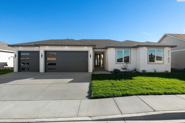 prairie-style home with a garage and a front yard