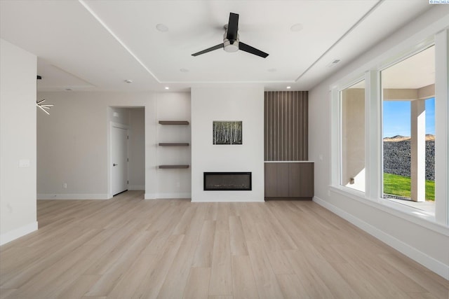 unfurnished living room featuring ceiling fan and light hardwood / wood-style flooring