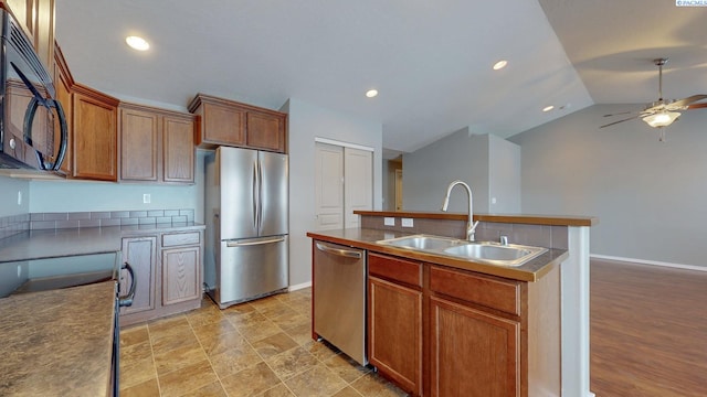 kitchen with a center island with sink, appliances with stainless steel finishes, sink, lofted ceiling, and ceiling fan