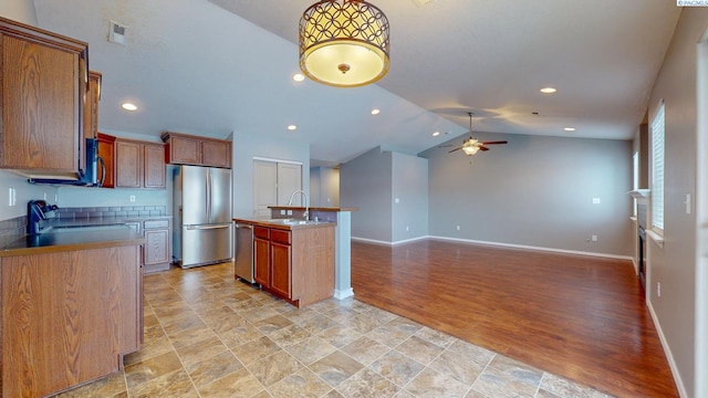 kitchen with a center island with sink, stainless steel appliances, lofted ceiling, ceiling fan, and sink