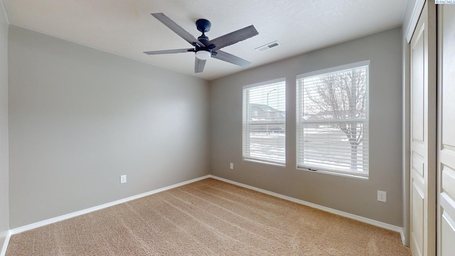 unfurnished room featuring ceiling fan and light carpet