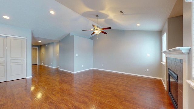 unfurnished living room featuring a fireplace, vaulted ceiling, dark hardwood / wood-style floors, and ceiling fan