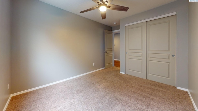 unfurnished bedroom featuring a closet, ceiling fan, and light colored carpet