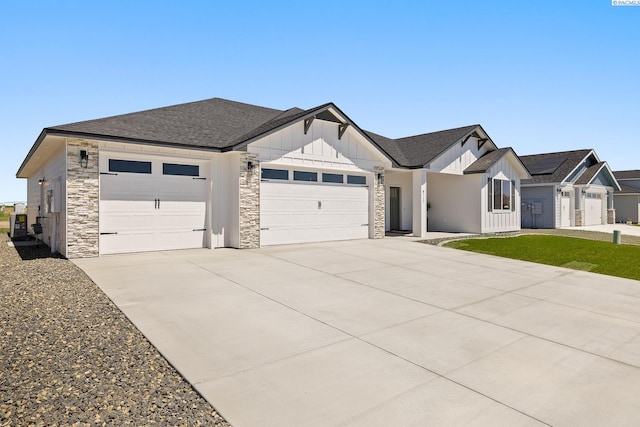 8717 Ashen Dr, Pasco, WA 99301 - modern farmhouse style home featuring board and batten siding, a garage, driveway, stone siding, and roof with shingles