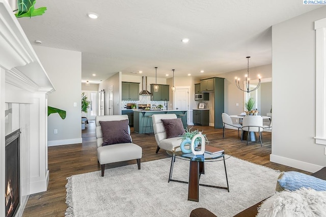 8717 Ashen Dr, Pasco, WA 99301 - living area with baseboards, recessed lighting, dark wood-type flooring, a chandelier, and a lit fireplace