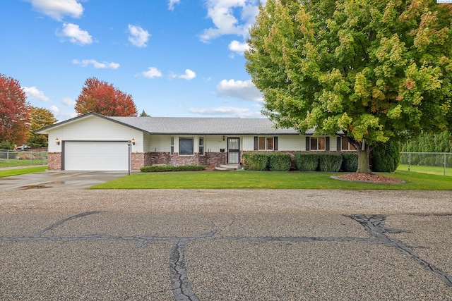 ranch-style house featuring a garage and a front lawn