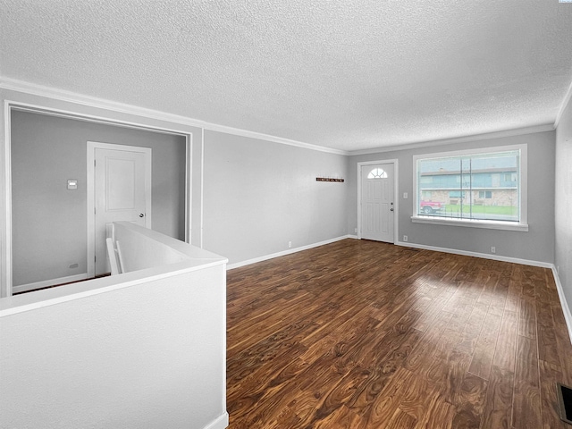 spare room with crown molding, dark hardwood / wood-style floors, and a textured ceiling