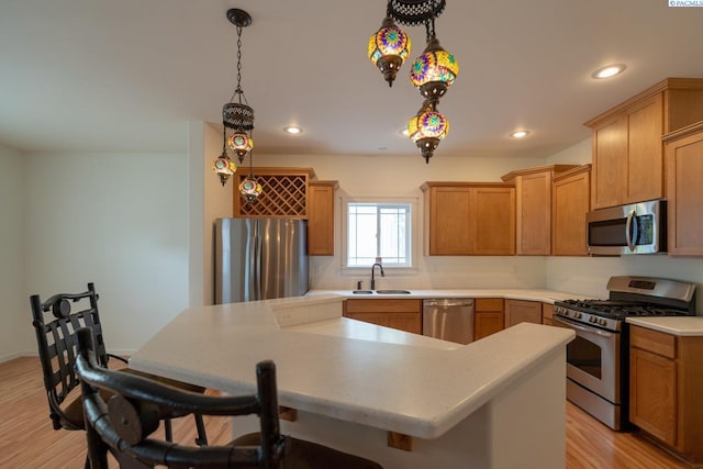 1205 SW Hannah St, Pullman, WA 99163 - kitchen with a kitchen bar, light countertops, a sink, light wood finished floors, and appliances with stainless steel finishes