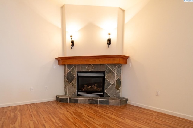 1205 SW Hannah St, Pullman, WA 99163 - unfurnished living room featuring a tiled fireplace, baseboards, and wood finished floors