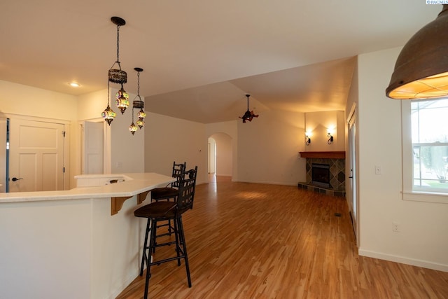 1205 SW Hannah St, Pullman, WA 99163 - kitchen with light wood-style floors, light countertops, arched walkways, a breakfast bar area, and baseboards