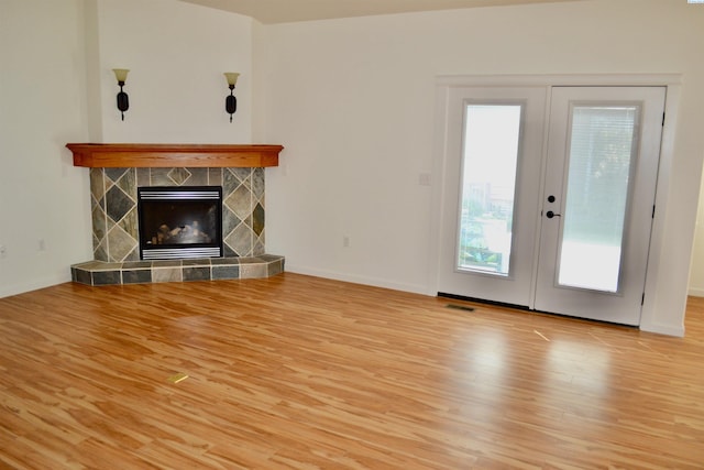 1205 SW Hannah St, Pullman, WA 99163 - unfurnished living room with a glass covered fireplace, french doors, baseboards, wood finished floors, and visible vents