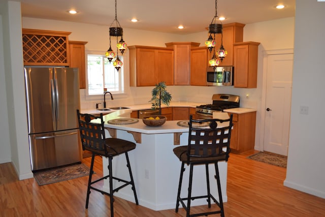 1205 SW Hannah St, Pullman, WA 99163 - kitchen featuring appliances with stainless steel finishes, a kitchen bar, light countertops, light wood-style flooring, and recessed lighting