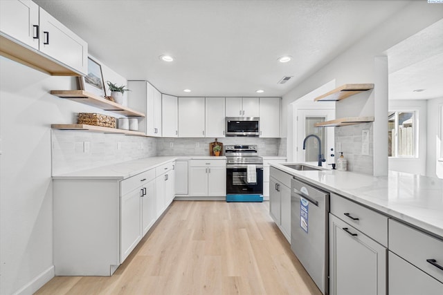 2008 Tinkle St, Richland, WA 99352 - kitchen with open shelves, stainless steel appliances, a sink, light wood-style floors, and light stone counters