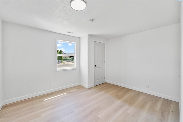 2008 Tinkle St, Richland, WA 99352 - unfurnished room with light wood-style floors, baseboards, and a textured ceiling
