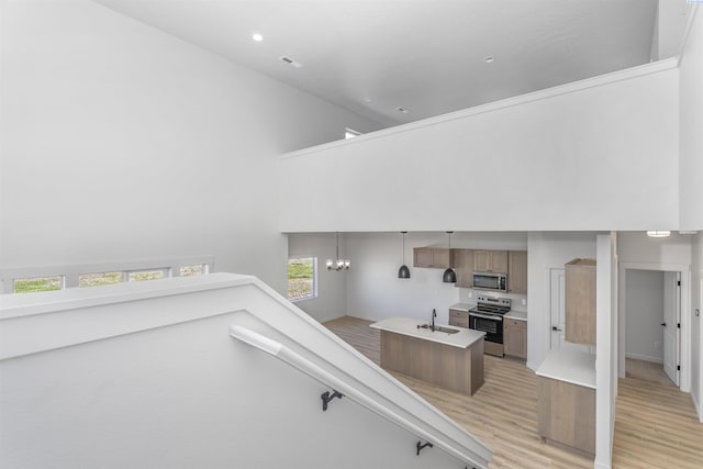 stairway featuring recessed lighting, a chandelier, wood finished floors, a high ceiling, and baseboards