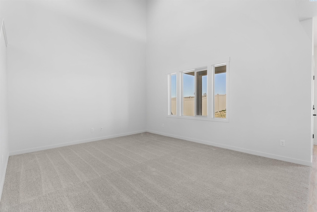 carpeted spare room with baseboards