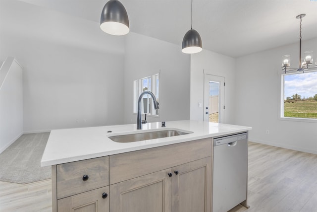 kitchen featuring dishwasher, light countertops, a sink, and a healthy amount of sunlight