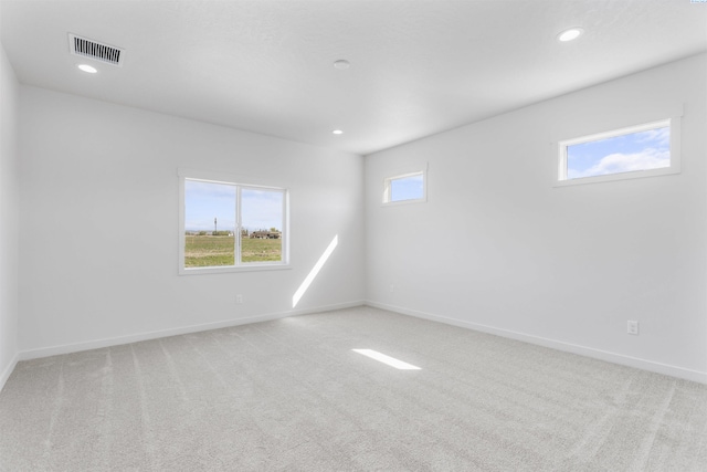 carpeted spare room with baseboards, visible vents, and recessed lighting