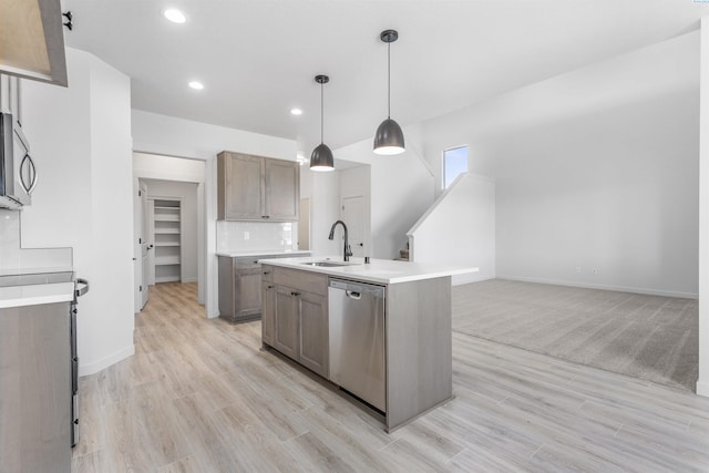 kitchen with light wood-style floors, recessed lighting, appliances with stainless steel finishes, a sink, and baseboards
