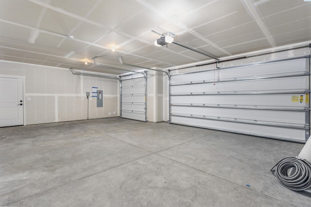 garage with a garage door opener and electric panel