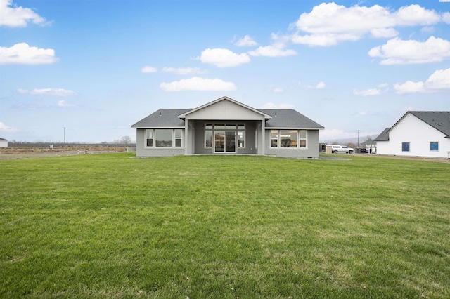 rear view of house featuring a yard