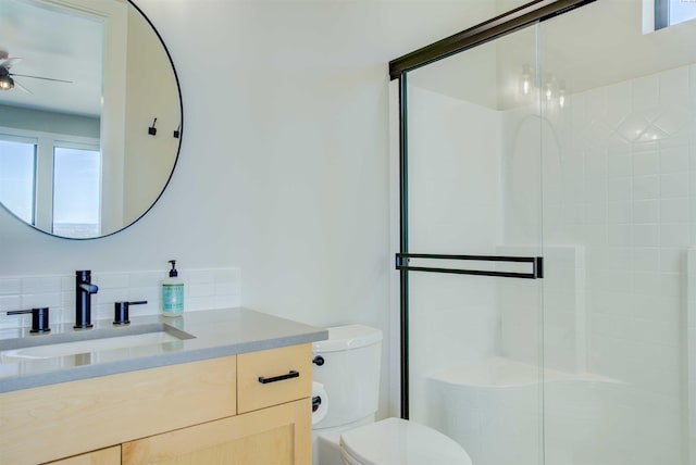 bathroom with walk in shower, vanity, and toilet