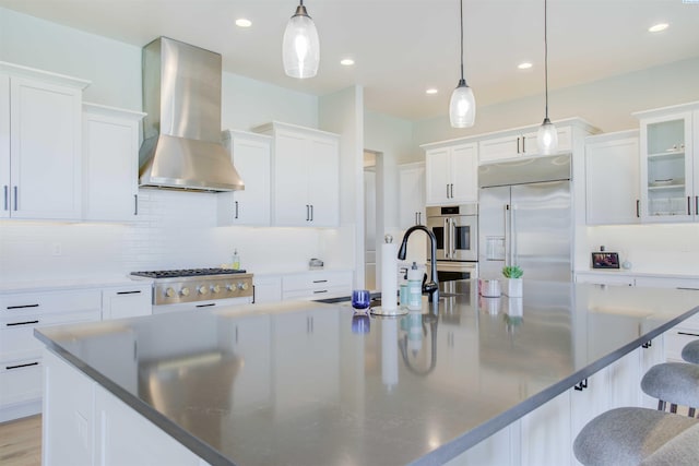 kitchen with stainless steel appliances, extractor fan, pendant lighting, and white cabinetry