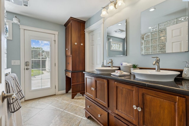 bathroom featuring double vanity, tile patterned floors, and baseboards