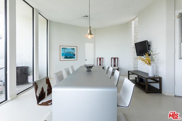 dining space with a textured ceiling and floor to ceiling windows