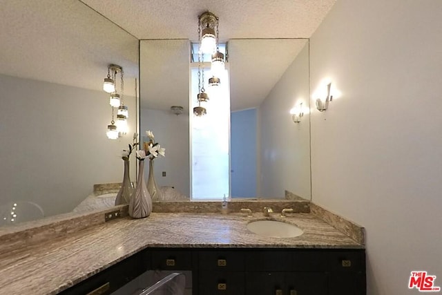 bathroom featuring a textured ceiling and vanity