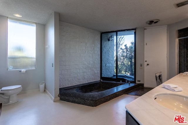 bathroom with double sink vanity, a textured ceiling, and toilet