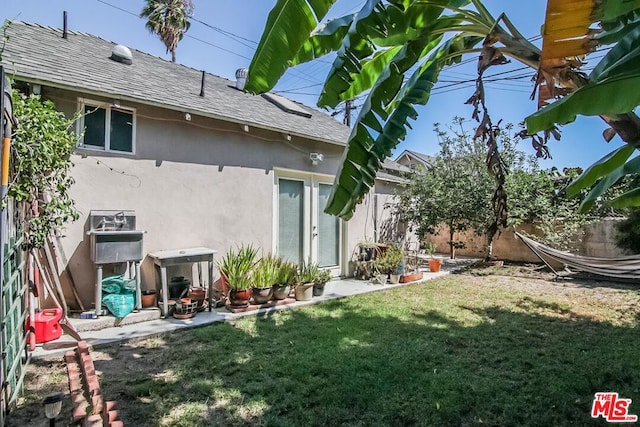 back of house with a lawn and a patio area