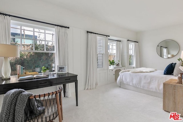 carpeted bedroom featuring multiple windows