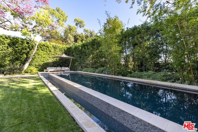 view of pool featuring a lawn