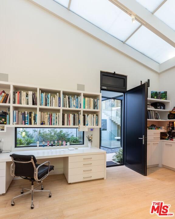 home office featuring light hardwood / wood-style floors and built in desk