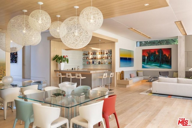 dining area with wooden ceiling, light hardwood / wood-style floors, and indoor bar