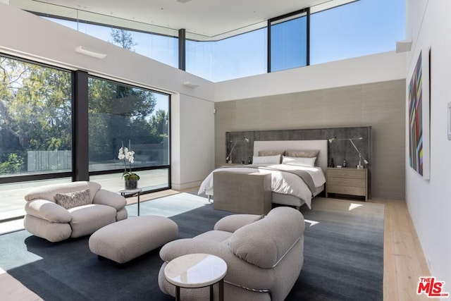 bedroom with a towering ceiling and wood-type flooring