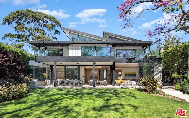 back of house with a yard, an outdoor living space, a pergola, and a patio